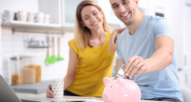 young couple with piggy bank at home